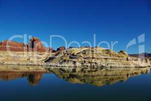 Red and white rock reflection in Colorado River near Hite, Utah
