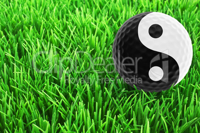 Golf-ball with Yin-Yang-Symbol on the fairway - golf wellness co