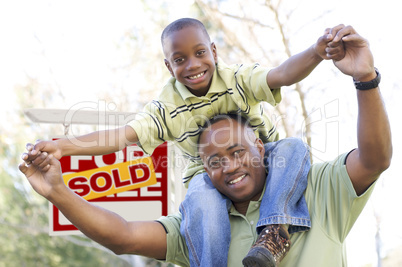 Father and Son In Front of Real Estate Sign