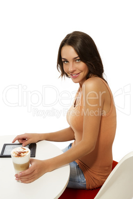 schöne glückliche frau sitzt an einem tisch mit latte macchiato und ebook