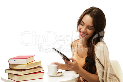 glückliche junge frau liest ebook an einem tisch mit büchern und kaffee