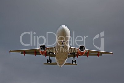 Passenger jet landing against a grey sky