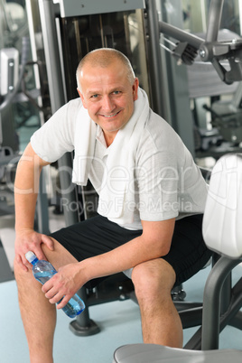 Active man relax sitting by fitness machine