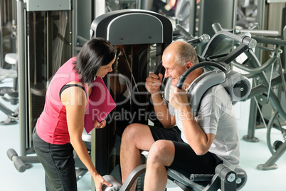 Mature man exercising with personal trainer