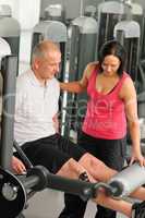 Fitness center active man exercising with trainer