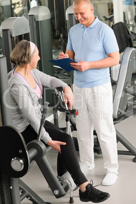 Physiotherapist assist active senior woman at gym