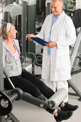 Physiotherapist assist active senior woman at gym