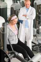 Physiotherapist assist active senior woman at gym