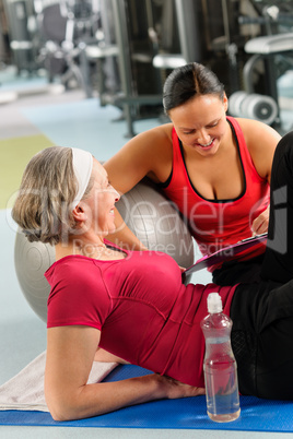 Senior woman on mat with personal trainer
