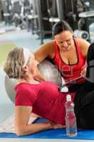 Senior woman on mat with personal trainer