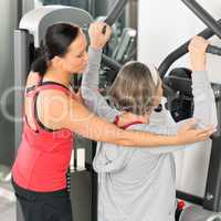 Fitness center trainer senior woman exercise back