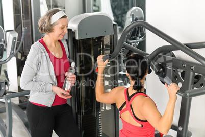 Personal trainer at fitness center showing exercise