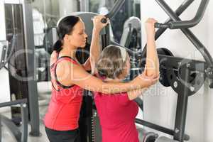 Senior woman at fitness center exercise shoulder