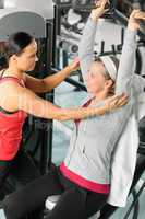 Senior woman at fitness center with trainer