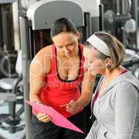 Personal trainer with senior woman at gym