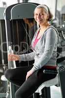 Senior woman relax sitting by fitness machine
