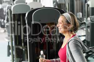 Senior woman relax sitting by fitness machine