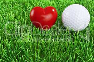 Red heart and white golf ball on the fairway