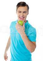 Handsome young caucasian biting an apple