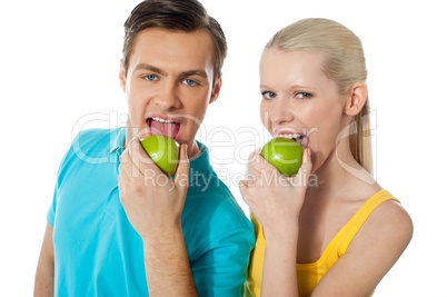 Healthy couple eating fresh green apple