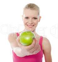 Healthy teenager offering green apple to you