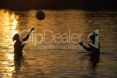 paar spielt ball im wasser