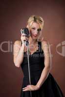 woman pin-up portrait in black with microphone