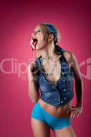 beauty blond girl lick candy on pink background