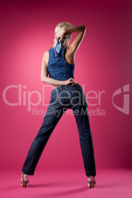 sexy blond woman posing in jeans on pink