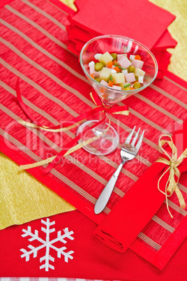 Beautifully decorated portion of Russian salad stands on the hol