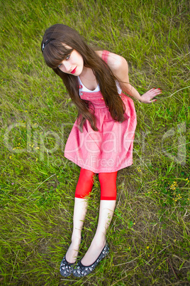 Pretty girl in red sarafan lies on the green grass