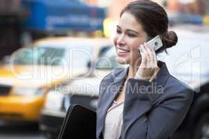 Young Woman Talking on Cell Phone by Yellow Taxi