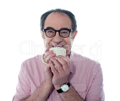 Senior man smiling and enjoying coffee