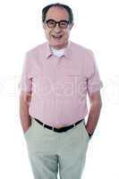 Smiling casual senior man with hands in pocket