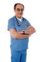 Smiling matured doctor posing with folded arms