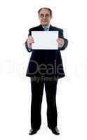 Senior business professional holding blank billboard