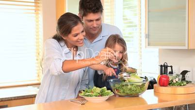 Familie bereitet einen Salat zu