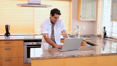 Mann mit Laptop in der Küche
