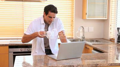 Mann in der Küche mit Laptop