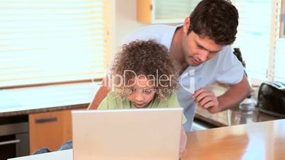 Vater und Sohn mit Laptop und Tablet