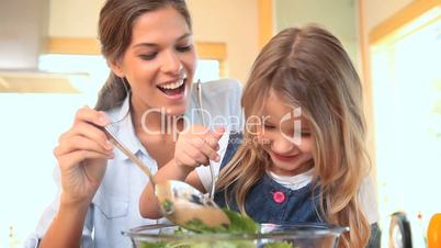 Mutter und Kind bereiten einen Salat zu