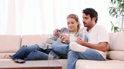Junges Paar trinkt Kaffee auf dem Sofa