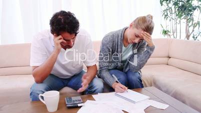Junges Paar sitzt über Rechnungen