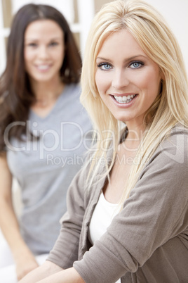 Two Young Women Friends At Home on Sofa
