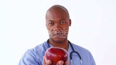 Junger schwarzer Arzt mit einem Apfel