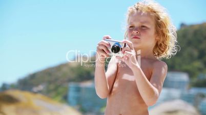 Kind macht ein Foto am Meer