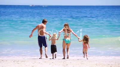 Familie rennt ins Meer