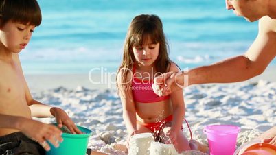 Familie spielt im Sand