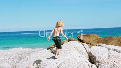 Kind  am Strand zwischen Steinen