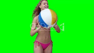 Frau im Bikini spielt Beachball